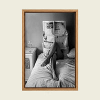 Woman Reading the Newspaper in Bed canvas wall art in a floating oak frame