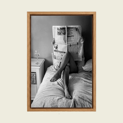 Woman Reading the Newspaper in Bed canvas wall art in a floating oak frame