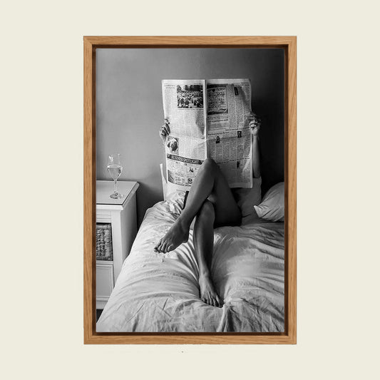 Woman Reading the Newspaper in Bed canvas wall art in a floating oak frame