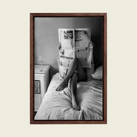 Woman Reading the Newspaper in Bed canvas wall art in a floating walnut frame