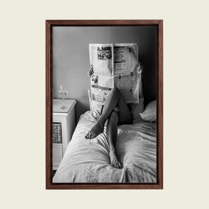 Woman Reading the Newspaper in Bed canvas wall art in a floating walnut frame